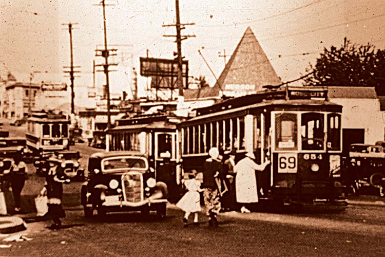 Trolleys share the road with cars in the 1920s